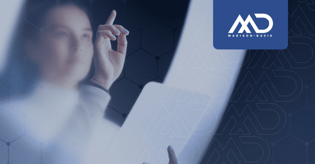 Female employee seen through frosted glass, holding a tablet and tapping an invisible screen