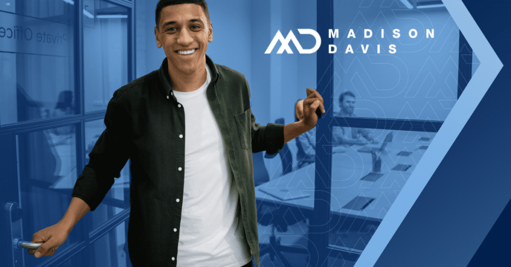 Smiling employee holding the door open in an office doorway