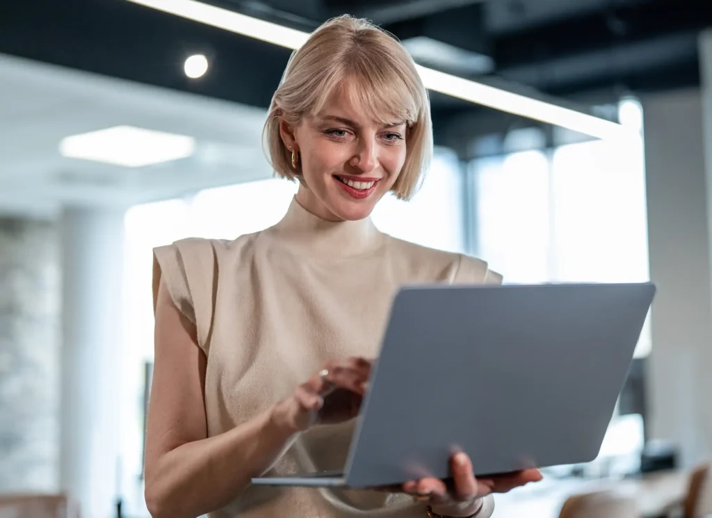 using laptop standing in modern office